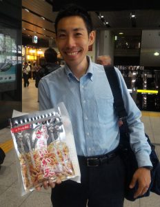 伍魚福のピリ辛さきか天を持つ笑顔のサラリーマン_新大阪駅にて